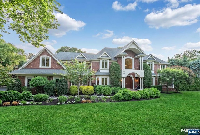 view of front of house featuring brick siding and a front yard