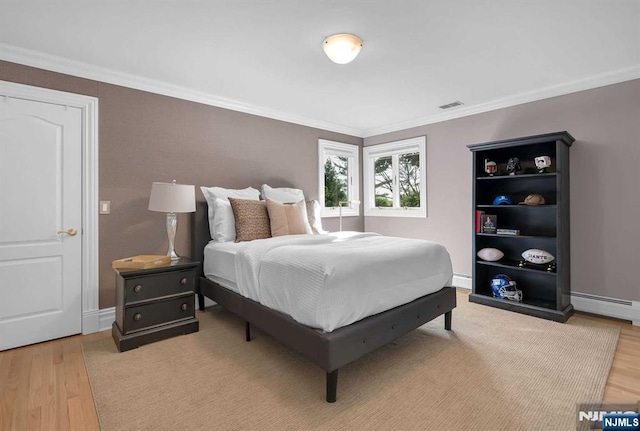 bedroom with a baseboard radiator, visible vents, wood finished floors, and ornamental molding