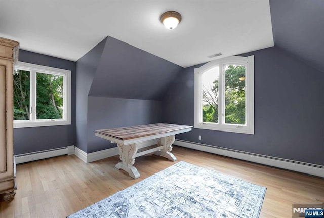 bonus room with a wealth of natural light, a baseboard radiator, visible vents, and light wood-style floors