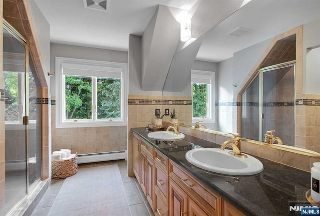 bathroom featuring a baseboard radiator, tile walls, a sink, and a shower stall