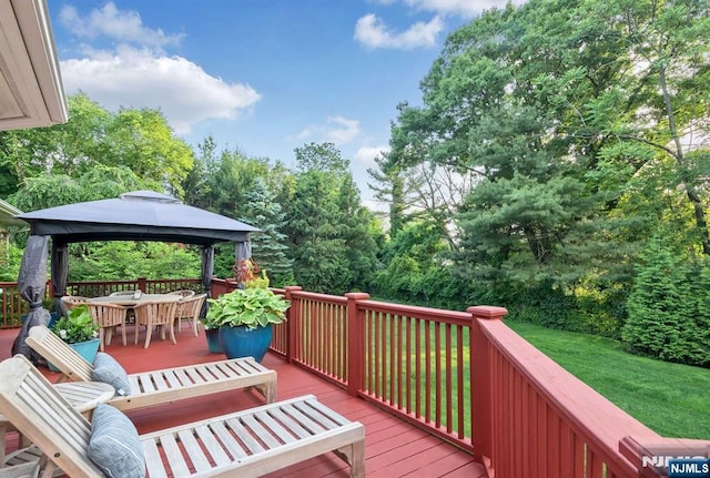 deck with a gazebo, outdoor dining area, and a lawn