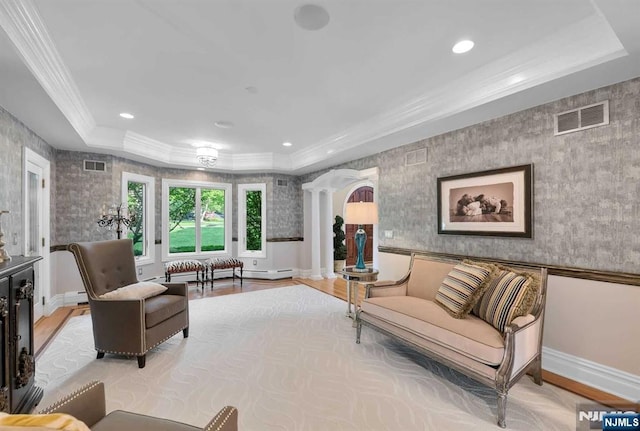 living room featuring a tray ceiling, visible vents, light wood-style flooring, and wallpapered walls