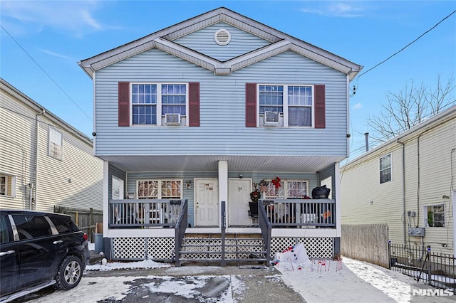 view of front of property with cooling unit, a porch, and fence