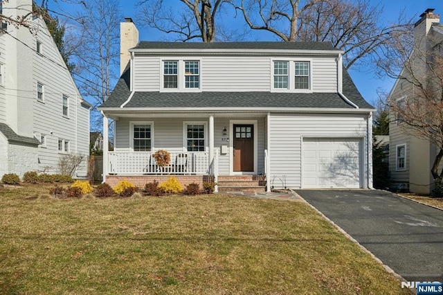 traditional-style home featuring a chimney, roof with shingles, a front lawn, a porch, and driveway