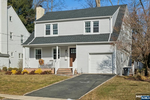 view of front of property with roof with shingles, an attached garage, a front yard, and a chimney