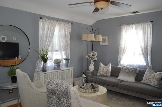 living room with a wealth of natural light, vaulted ceiling, and ceiling fan