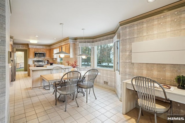 kitchen with light tile patterned floors, stainless steel appliances, a peninsula, ornamental molding, and brown cabinets