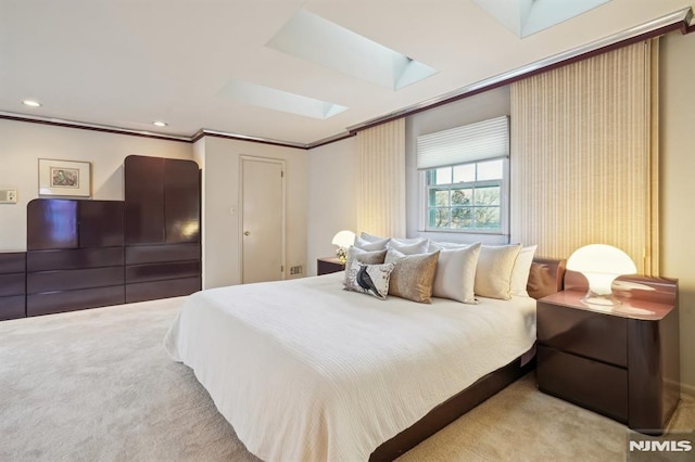 bedroom featuring light carpet, a skylight, ornamental molding, and recessed lighting