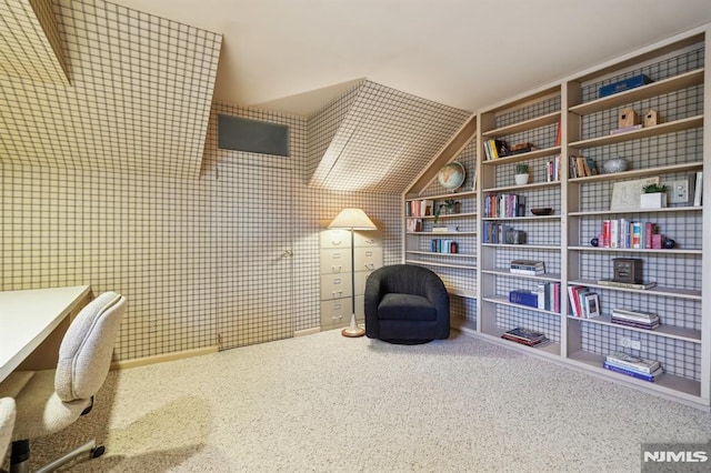 interior space featuring carpet floors, vaulted ceiling, and built in features