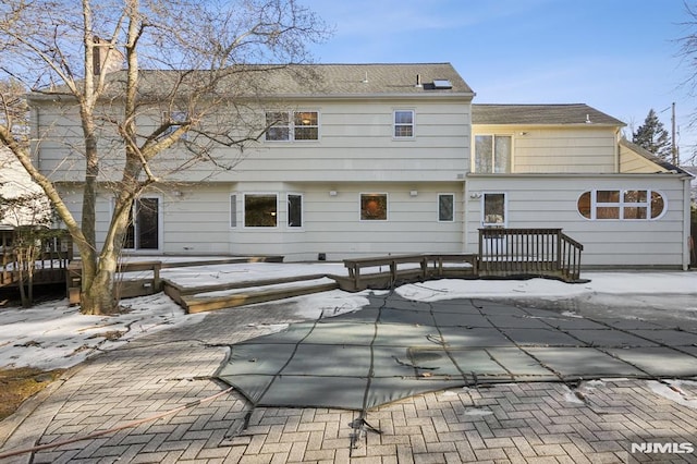 snow covered house with a chimney and a deck