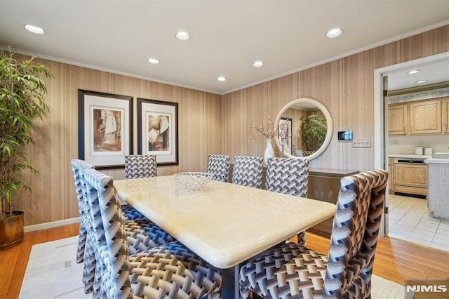 dining area with light wood finished floors, crown molding, and recessed lighting