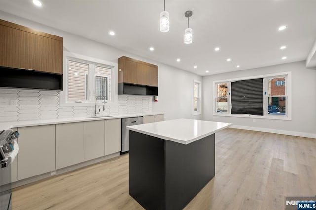 kitchen with light countertops, hanging light fixtures, brown cabinetry, appliances with stainless steel finishes, and white cabinetry