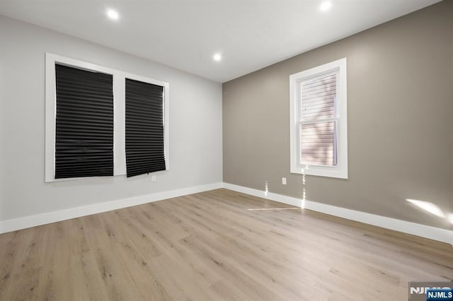 unfurnished room featuring recessed lighting, light wood-style flooring, and baseboards