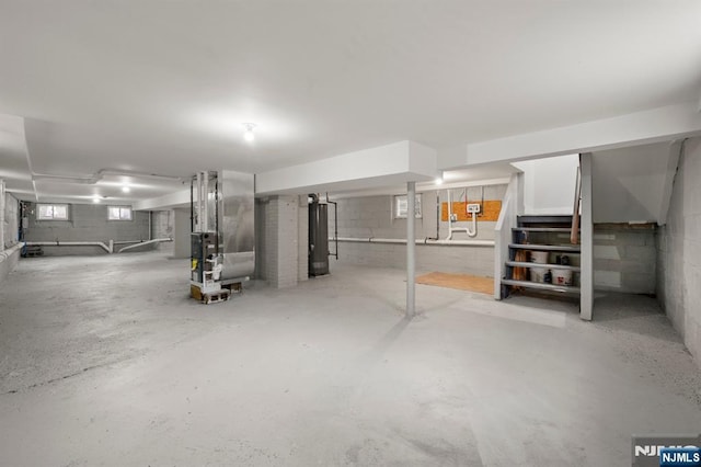 basement featuring gas water heater, stairway, and heating unit