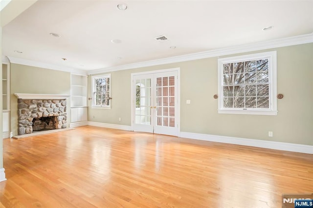 unfurnished living room with ornamental molding, french doors, and light wood finished floors