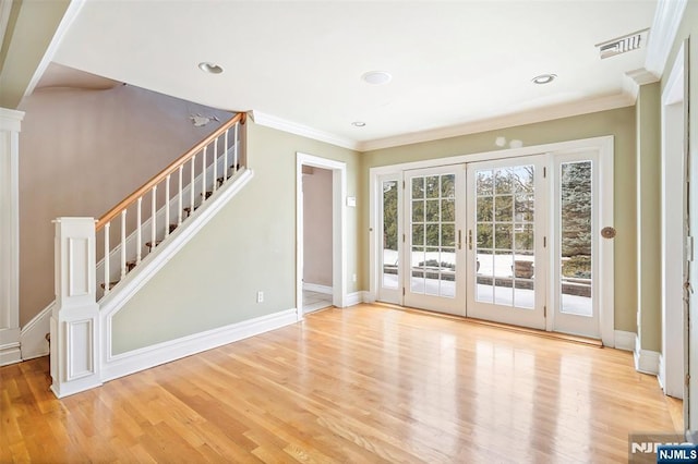 doorway with french doors, crown molding, visible vents, wood finished floors, and stairs