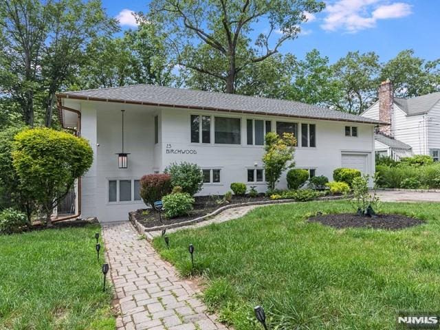 raised ranch with driveway and a front yard