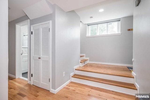 stairway featuring baseboards, wood finished floors, and recessed lighting