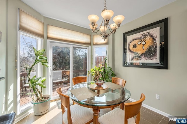 tiled dining room featuring baseboards and a chandelier