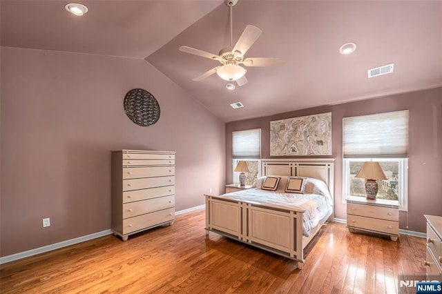 bedroom with vaulted ceiling, light wood-type flooring, visible vents, and baseboards