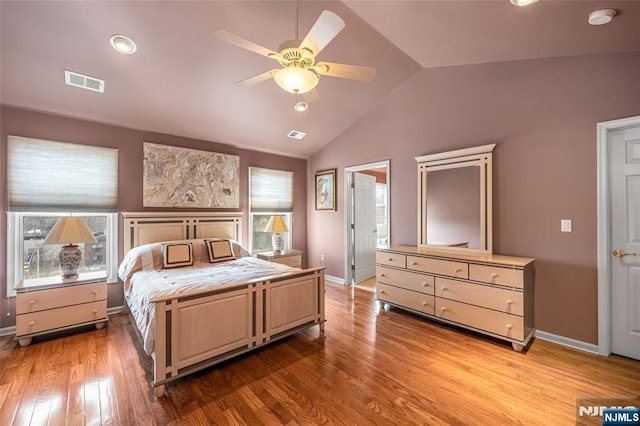 bedroom featuring vaulted ceiling, light wood-type flooring, visible vents, and baseboards