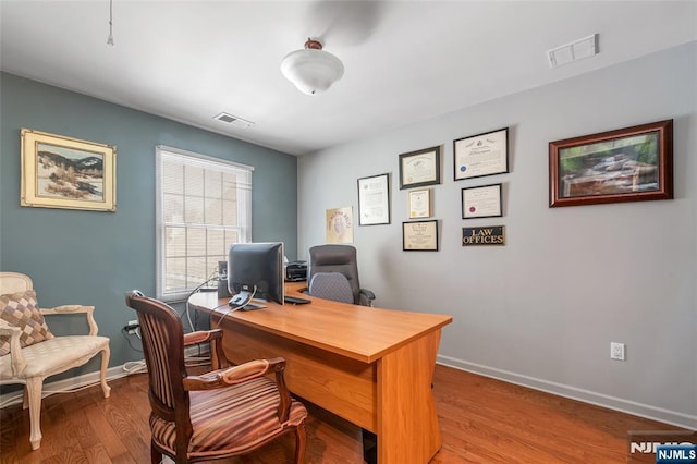 office area featuring wood finished floors, visible vents, and baseboards