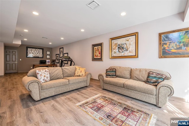 living area featuring light wood finished floors, baseboards, visible vents, and recessed lighting