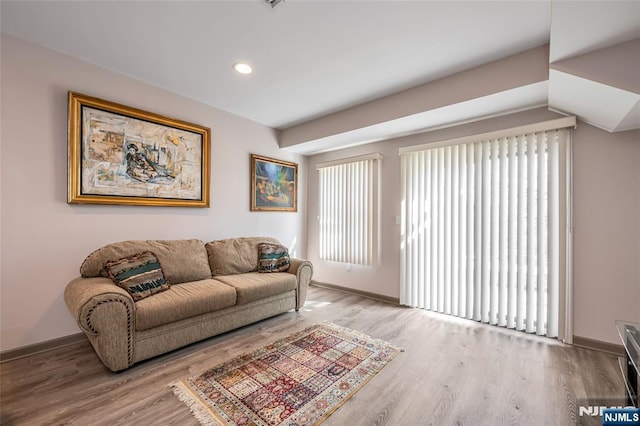 living area featuring light wood-type flooring, baseboards, and recessed lighting