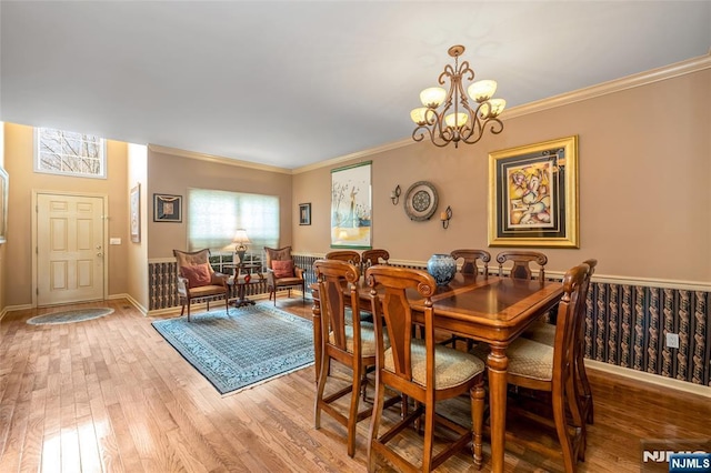 dining area with crown molding, baseboards, wood finished floors, and an inviting chandelier