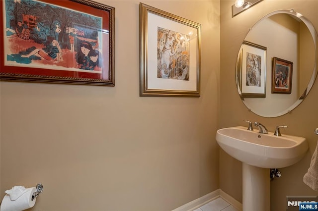 bathroom featuring a sink, tile patterned flooring, and baseboards