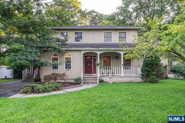 view of front of home featuring a porch, a front lawn, and aphalt driveway