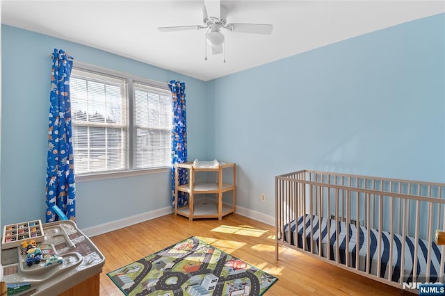 bedroom with a ceiling fan, baseboards, and wood finished floors