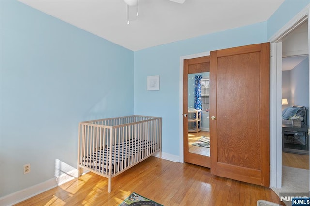 unfurnished bedroom with ceiling fan, light wood-style flooring, and baseboards