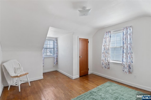 bonus room featuring lofted ceiling, baseboards, and wood finished floors