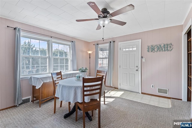 dining room with a ceiling fan, visible vents, baseboards, and light floors