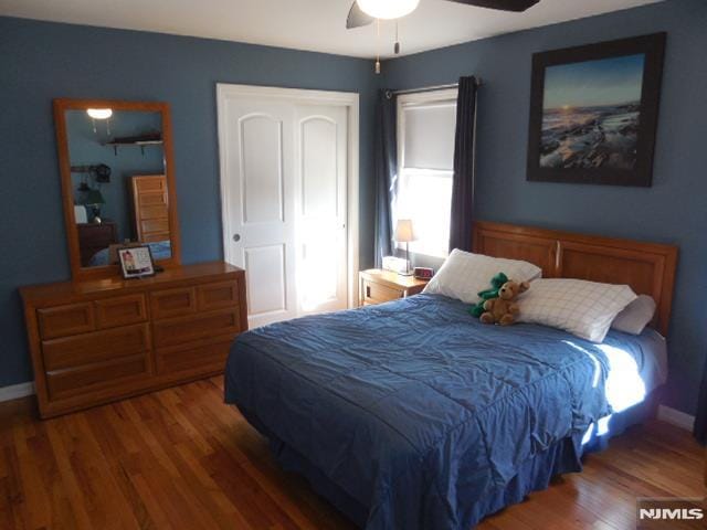 bedroom with a ceiling fan, baseboards, and wood finished floors