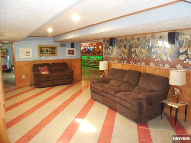 living area featuring a wainscoted wall and wooden walls