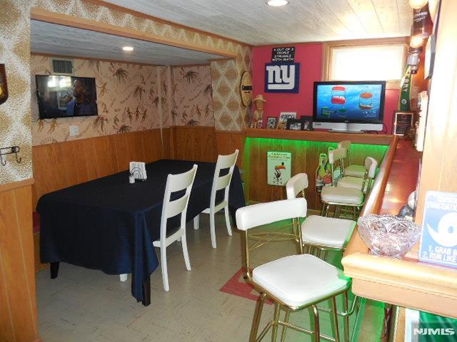 game room featuring wainscoting, tile patterned floors, visible vents, and wallpapered walls