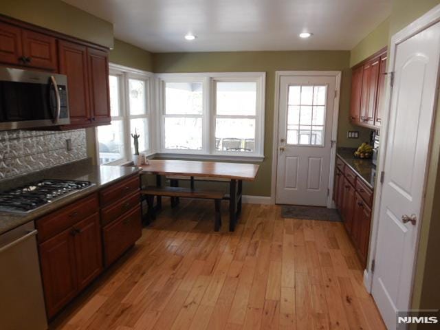 kitchen with stainless steel appliances, brown cabinets, light wood-style flooring, and recessed lighting