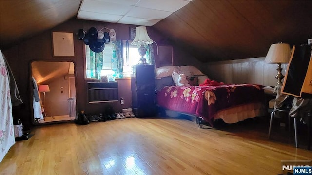 bedroom with lofted ceiling and wood finished floors