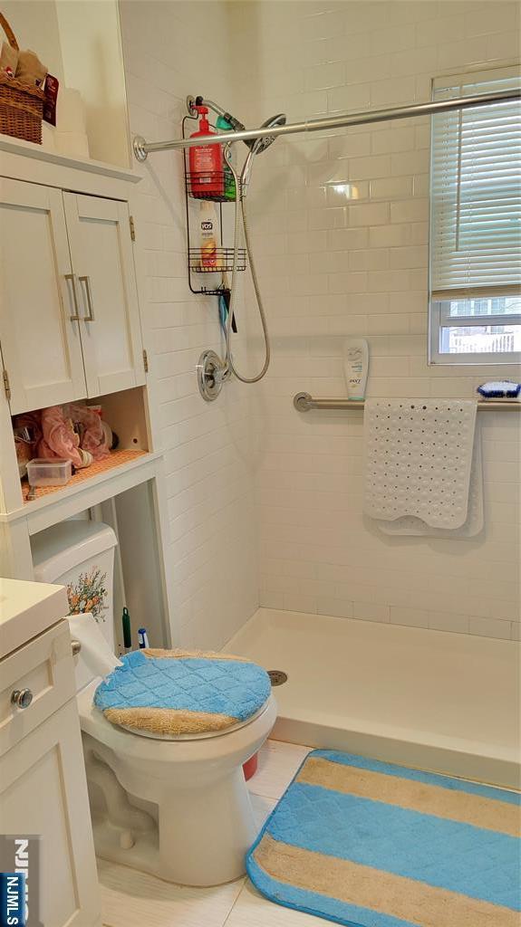 full bath with toilet, tile patterned floors, a shower stall, and vanity