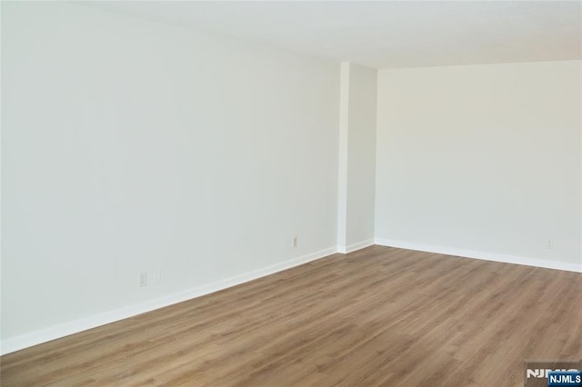 spare room featuring light wood-style flooring and baseboards