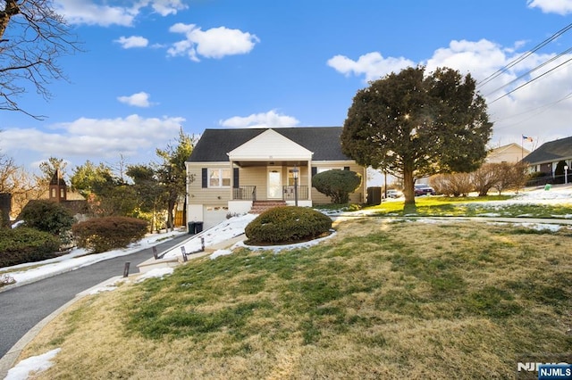 view of front facade with a garage, a porch, a front lawn, and concrete driveway