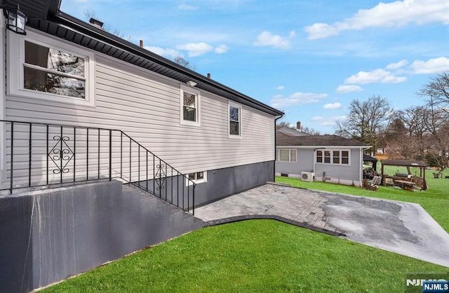 view of side of home featuring a patio area and a yard