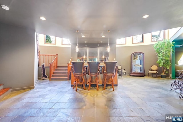 dining room featuring recessed lighting, a dry bar, and stairs