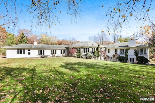 view of front of house featuring a chimney and a front yard