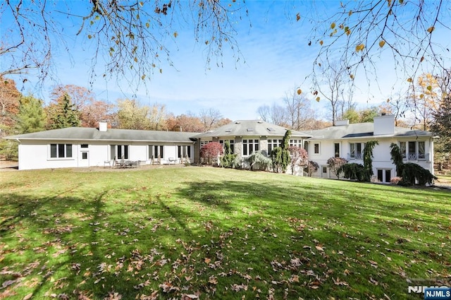 rear view of property with a yard and a chimney