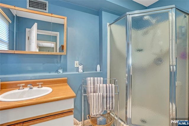 full bath with visible vents, a shower stall, and vanity