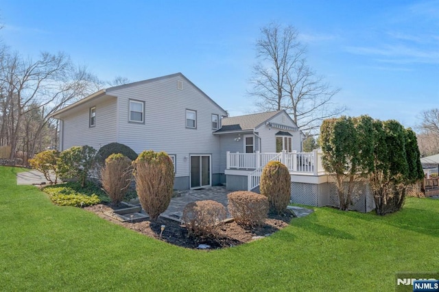 back of property featuring a yard and a wooden deck