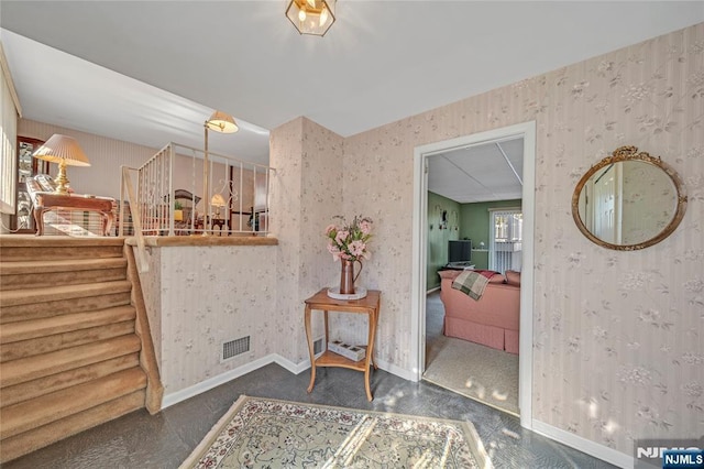 bathroom featuring baseboards, visible vents, and wallpapered walls